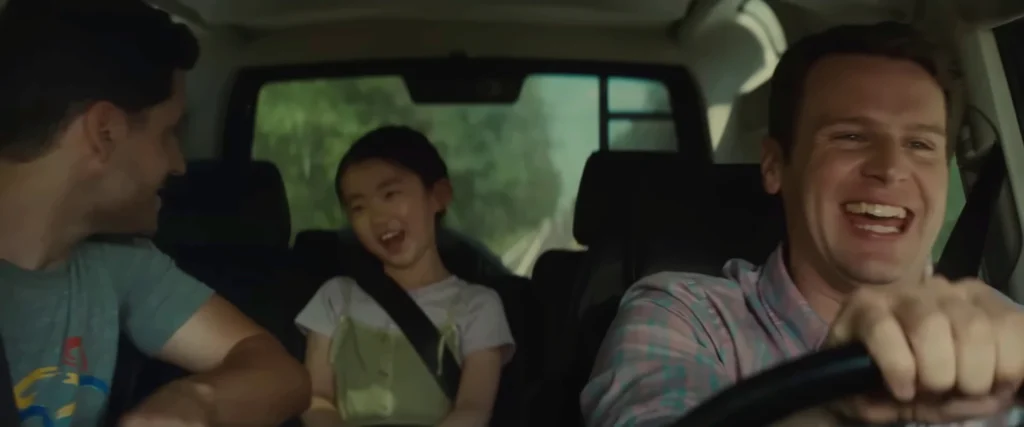 Wen smiles with Eric and Andrew during an earlier family car ride in the official Knock at the Cabin trailer
