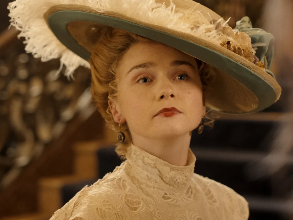 Jessica Barden as actress Nance O'Neil, wearing a wide feathered hat in Monster: The Lizzie Borden Story