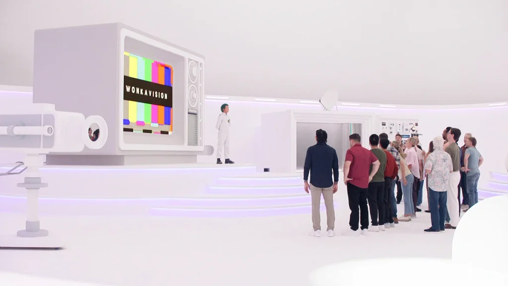 Contestants face a giant Wonkavision television in a bright white studio in Wonka's The Golden Ticket