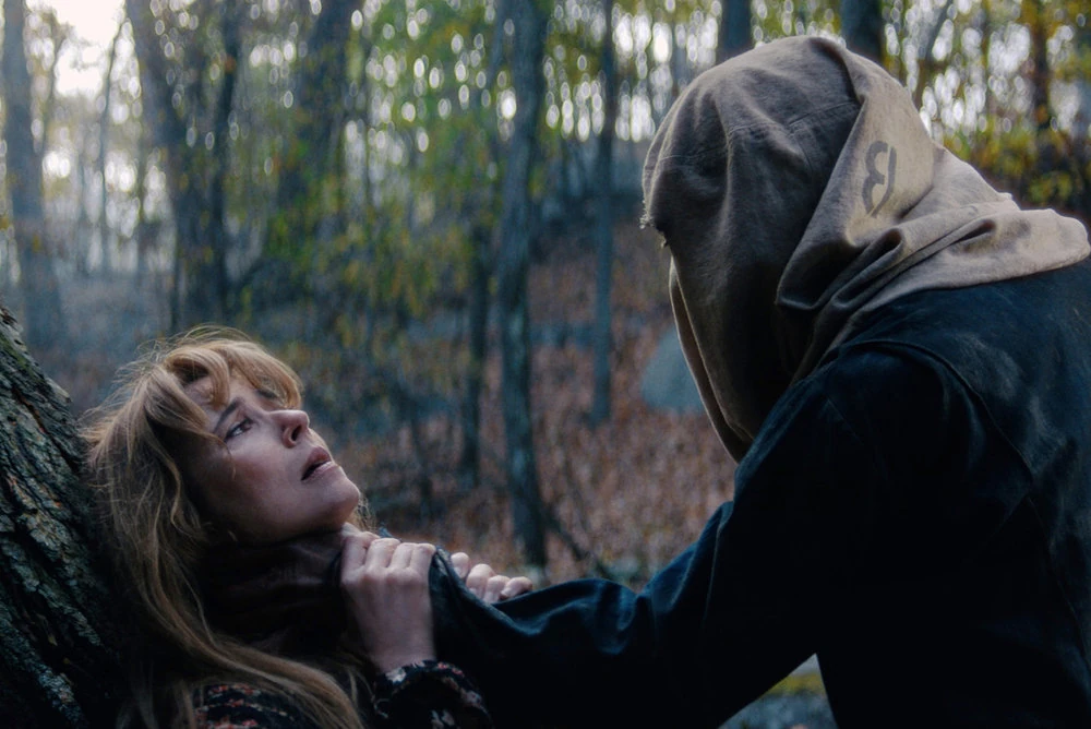 Pamela looks up at a sack-masked Jason as he holds her against a tree.