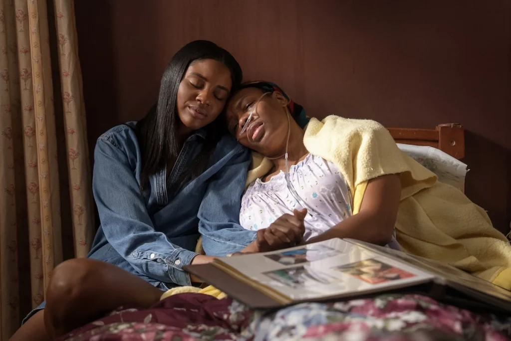 Anika sits beside her mother Cathy with an open photo album on their laps in Doing Life