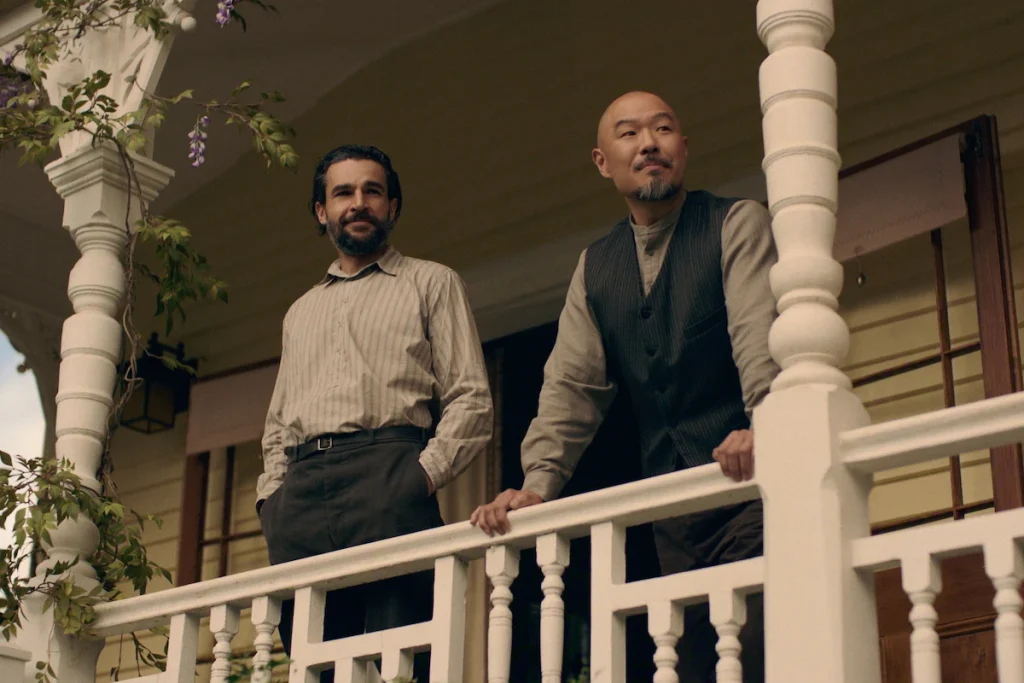 Adam and Lee stand at the railing of a porch in East of Eden.