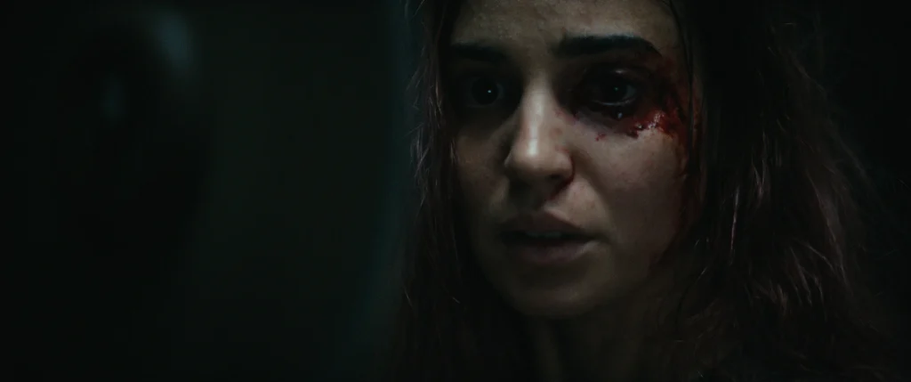Close-up of Alice with a bloodied injury beside her eye in Evil Dead Burn.