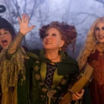 Hocus Pocus 2: Why Does Winning Cost Winifred Her Sisters? Winifred raises one hand while holding Book between Mary and Sarah in Hocus Pocus 2