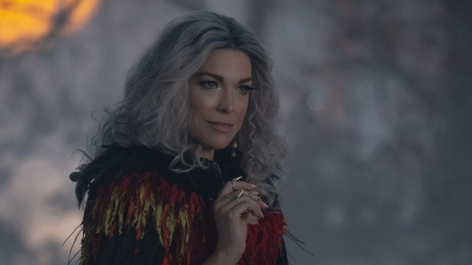 The Witch clasps her hands beneath a black feathered collar in Hocus Pocus 2