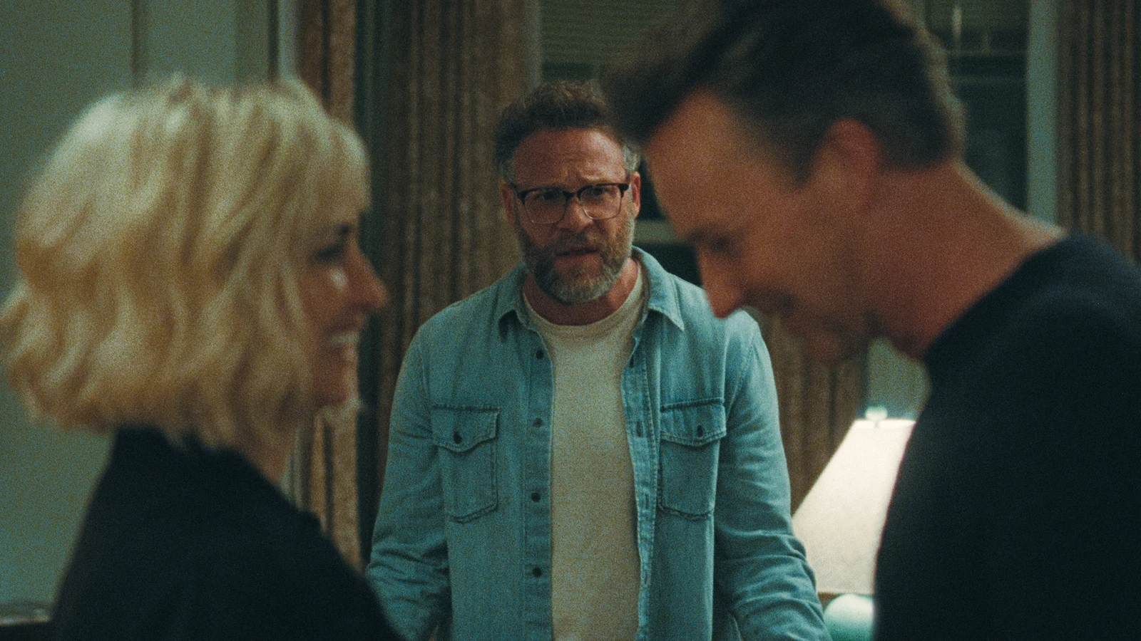 Joe stands between Pina and Hawk, who are out of focus in the foreground in The Invite.