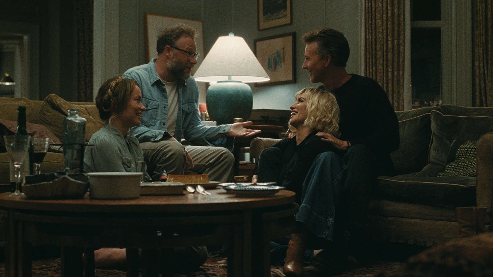 Angela and Joe sit opposite Pina and Hawk around a coffee table in The Invite.