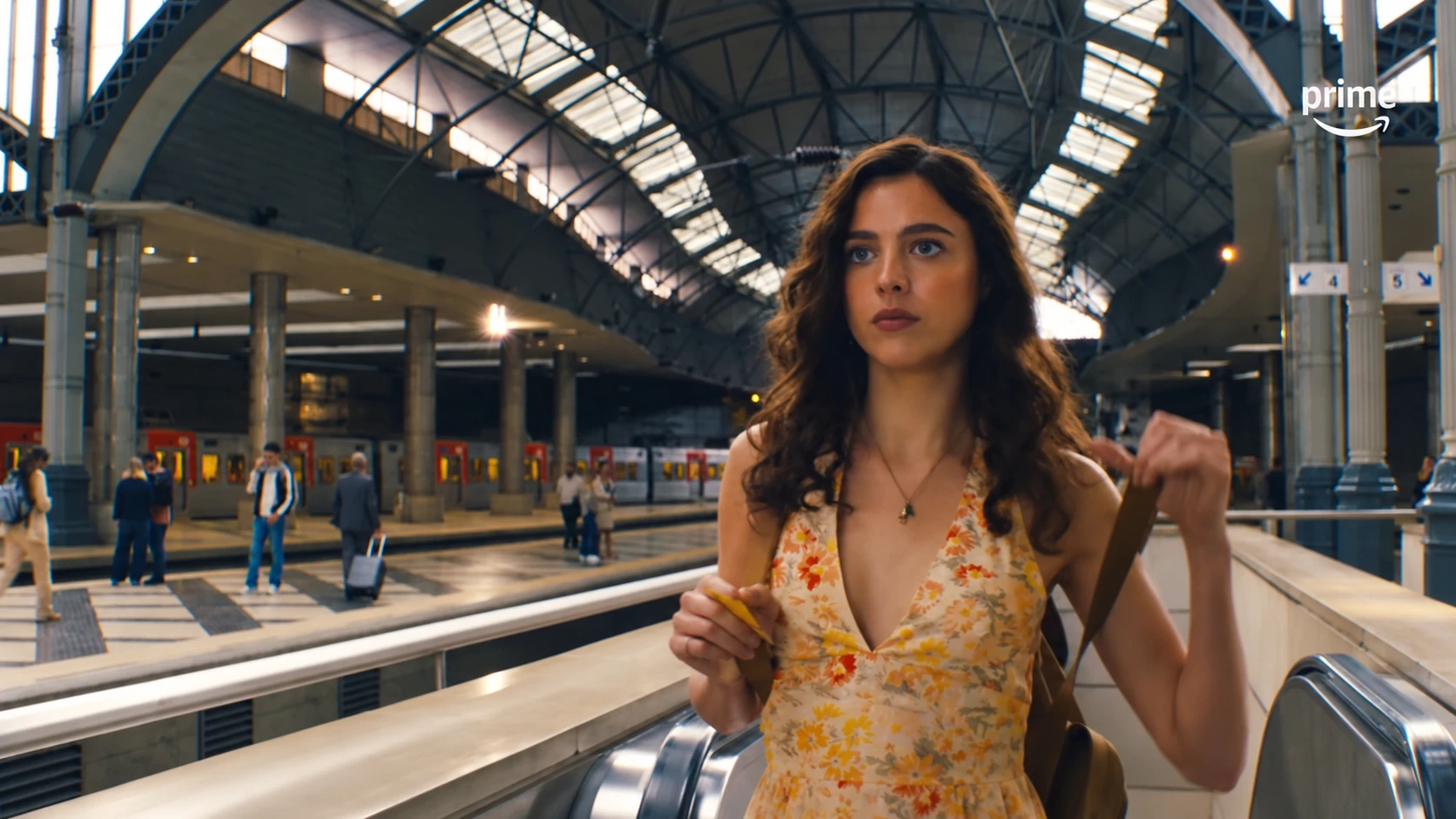 Maya rides an escalator beside railway platforms in Love of Your Life