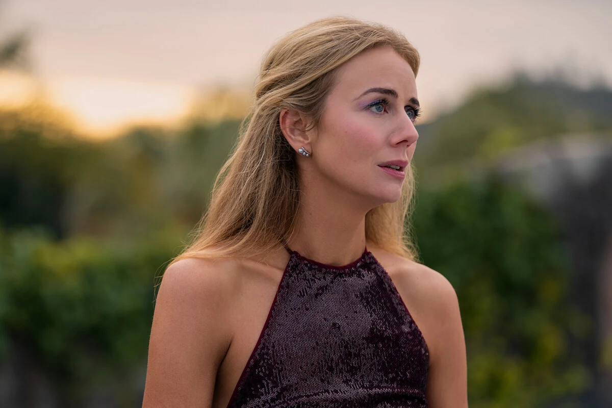 Morgan looks to the side outdoors, wearing a sleeveless sequined top.