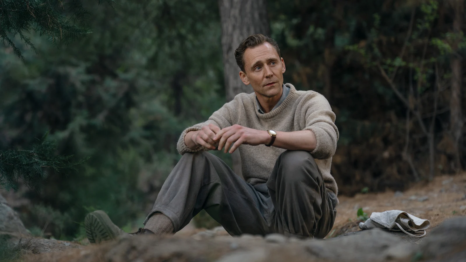 Edmund Hillary seated among trees in Tenzing