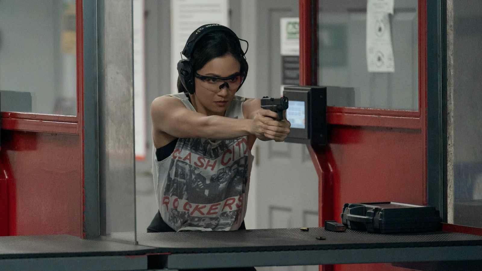 Katie Buranek aims a handgun while wearing safety glasses and hearing protection.