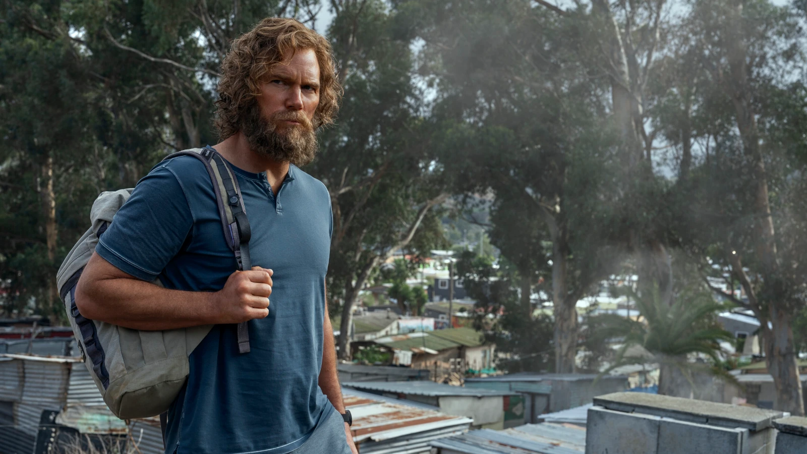 James Reece stands outdoors with a gray bag over one shoulder.